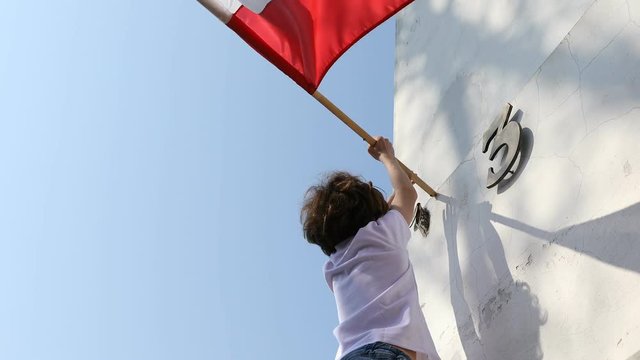 The boy is hanging a flag. Polish National Day of the Third of May, Constitution Day Flag Day, International Labor Day
