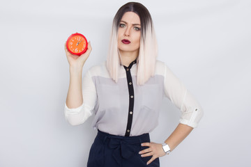 Blonde woman holding red alarm clock in her hands