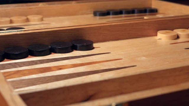 Dice rolled on a backgammon board game. NORMAL MOTION. LOW ANGLE.