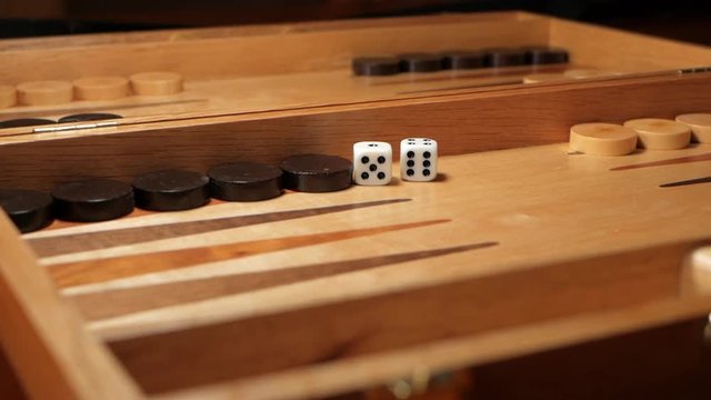 Dice rolled to start the game on a backgammon board game. SLOW MOTION. LOW ANGLE.