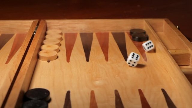 Dice rolled on a backgammon board game. Double sixes rolled. SLOW MOTION. LOW ANGLE. SLIDE SHOT.