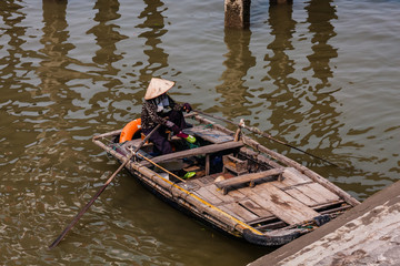 One of the ubiquitous traders of the floating market in Halong Bay, Vietnam
