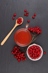 viburnum with juice, jam, tea on black background 