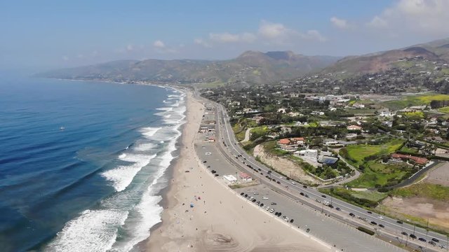 Drone footage taken from 400 feet of Zuma beach with waves rolling across the soft white sand. Shot in Malibu, California.