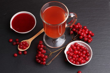 viburnum with juice, jam, tea on black background 