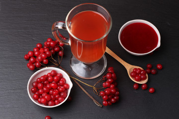 viburnum with juice, jam, tea on black background 