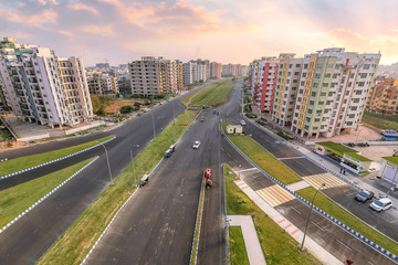 Fototapeta na wymiar City residential building apartments with adjacent roads in aerial view at sunset. Photograph shot at Newtown Rajarhat area of Kolkata, India