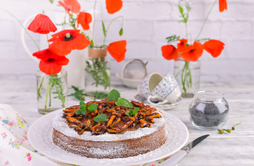 Pie with poppy seeds on a white background. Homemade pastries and red flowers.