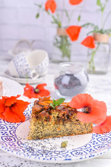 Pie with poppy seeds on a white background. Homemade pastries and red flowers.