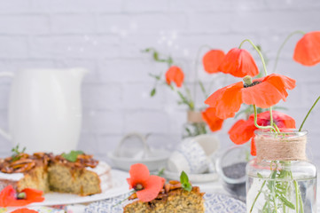 Pie with poppy seeds on a white background. Homemade pastries and red flowers.