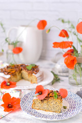 Pie with poppy seeds on a white background. Homemade pastries and red flowers.