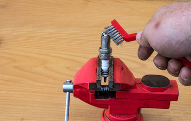 Mechanical spark plug cleaning technology with a metal brush