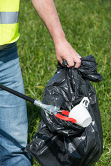 A man cleans a meadow from littering, a plastic bottle, for environmental protection in Uster,...