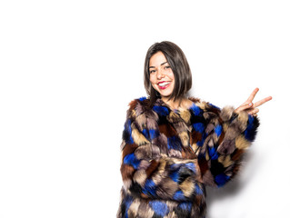 woman made up posing in a studio wearing a colorful coat