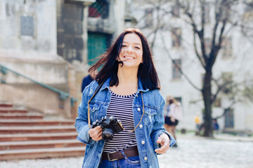 Outdoor spring portrait brunette caucasian woman walking on the street at sunny day, having fun alone, travel concept , young photographer with vintage camera. - obrazy, fototapety, plakaty