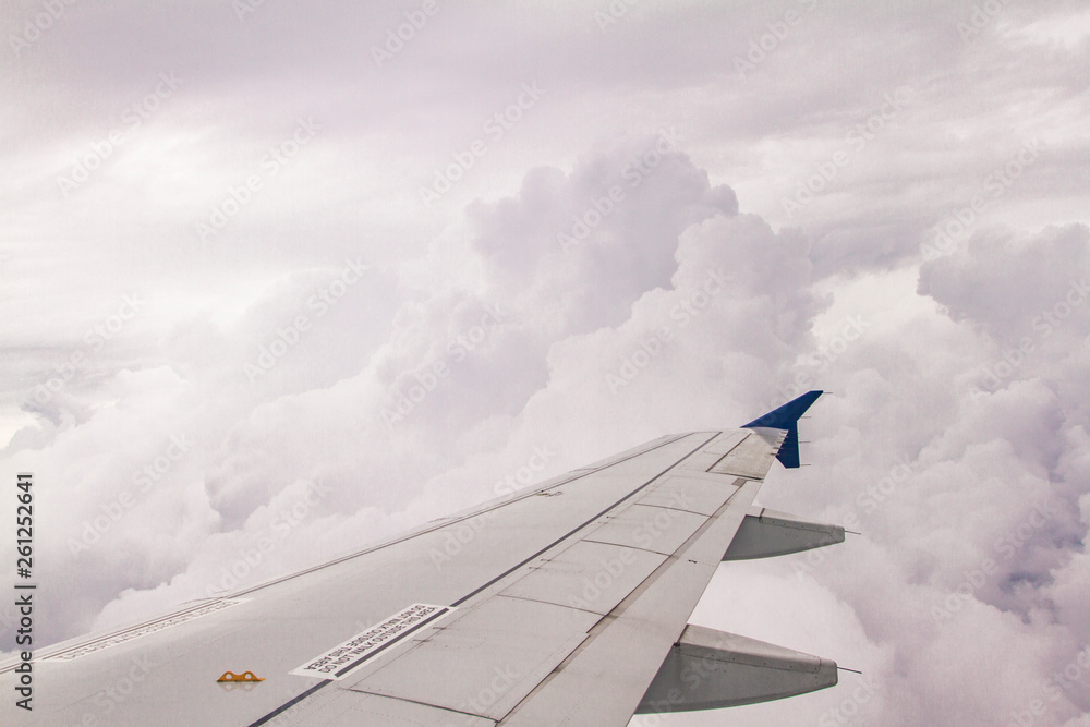 Wall mural wing of an airplane in clouds