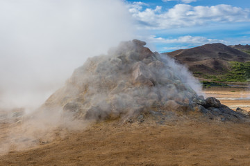 Hot spring in Hverir geothermal area with boiling mudpools and steaming fumaroles in Iceland