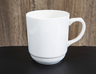 Empty white mug on a wooden table.