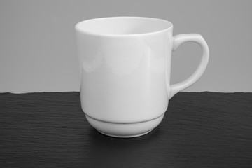 Empty white mug on a wooden table.