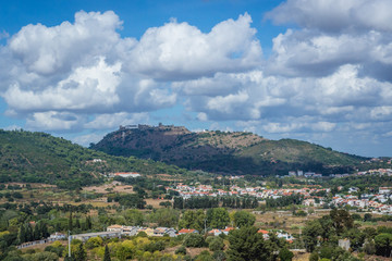 Fototapeta premium Distance view of Castelo de Palmela on a hill seen from Setubal city, Portugal