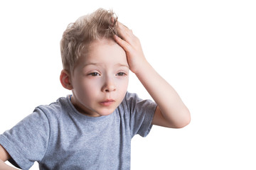 preschool boy holding his hand on his head on a white isolated background. the child hit his head
