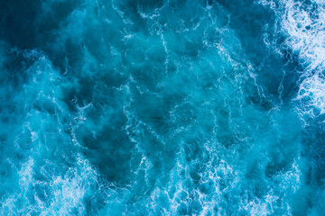 Top view of blue frothy sea surface. Shot in the open sea from above. - obrazy, fototapety, plakaty