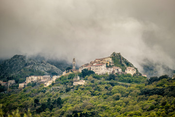 Clouds over mountain village of Speloncato in Corsica