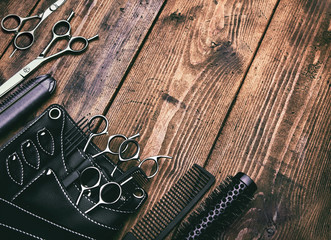 Stylish professional barber scissors on vintage wooden table, hairdresser salon concept,...
