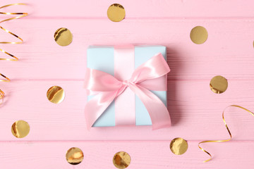 gift and sparkles of confetti on a colored background top view. minimalism, insta. flatlay 