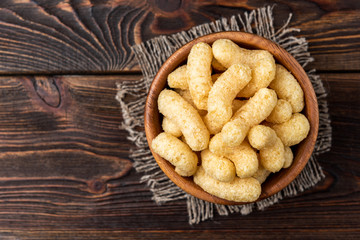 Corn sticks on dark wooden background.