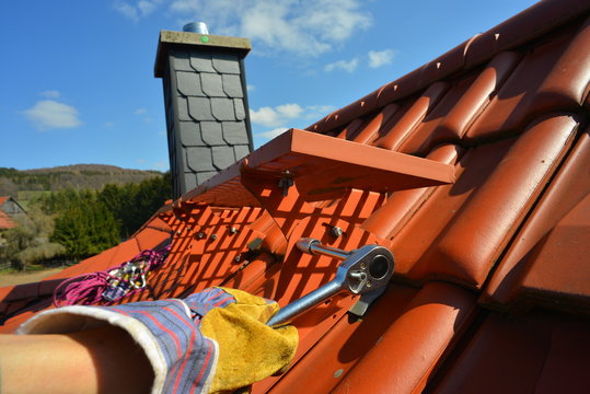 Montage eines Dachtrittes auf einem Ziegeldach mit Ratsche und Edelstahl-Muttern 