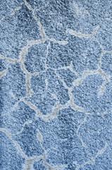 Old cracked blue relief plaster on wall closeup