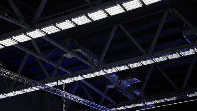 Lamps hanging under the blue ceiling structure steel in a large space. Stock footage. Steel structures under the roof