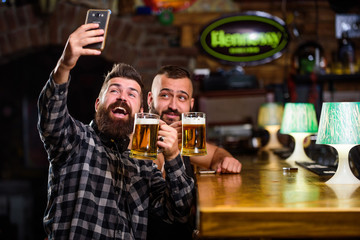 Man in bar drinking beer. Online communication. Man bearded hipster hold smartphone. Taking selfie concept. Take selfie photo to remember great evening in pub. Send selfie to friends social networks