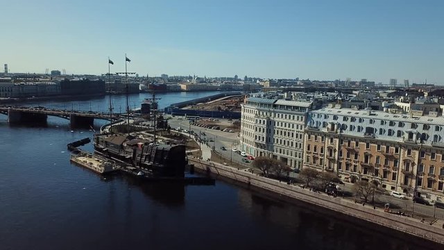 Aerial view of Russian cruiser Aurora near the bridge in Saint-Petersburg against blue sky. Stock footage. Petersburg landscape