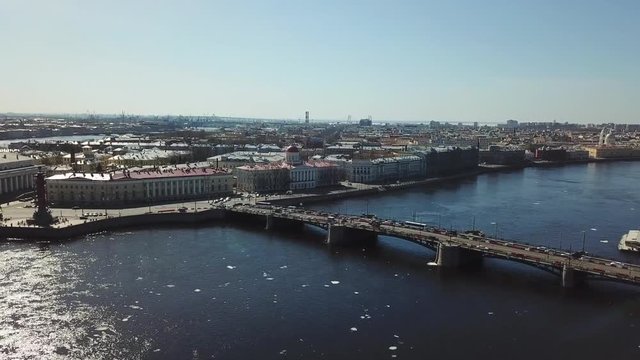 Aerial view of Saint-Petersburg's bridge across the Neva river and moving cars against blue sky. Stock footage. Petersburg landscape