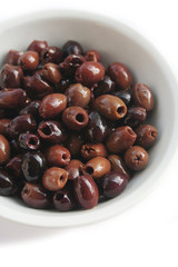 Italian Taggiasche olives in a bowl isolated on white background