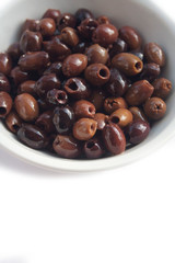 Italian Taggiasche olives in a bowl isolated on white background