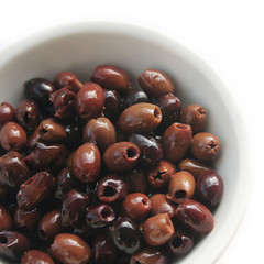 Italian Taggiasche olives in a bowl isolated on white background