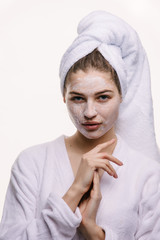 Woman on a white background clean face cream on face towel in hair on head 