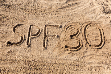 Sun protect factor thirty concept. SPF 30 word written on the beach