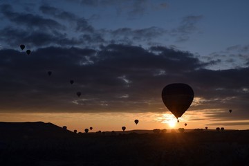 Sunrise and balloons. Beautiful background of the balloon and the sunset.Cappadocia. Turkey. Göreme. Nevşehir. Türkiye. 8. 04. 2019. Balloons flying over the rocky landscape in Cappadocia Turkey. View