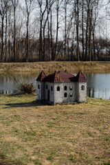 Doghouse in shape of a castle on the river bank in a park