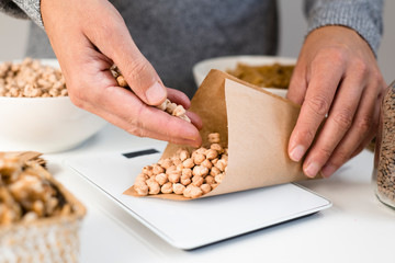 man weighing chickpeas on an electronic scale