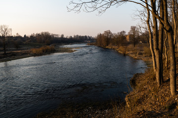 Warm landscape sunset at a river with a running spring water in Bauska, Latvia, 2019