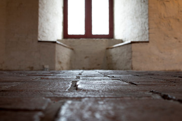 stone floor in foreground ancient window in background