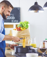 Smiling and confident chef standing in large kitchen