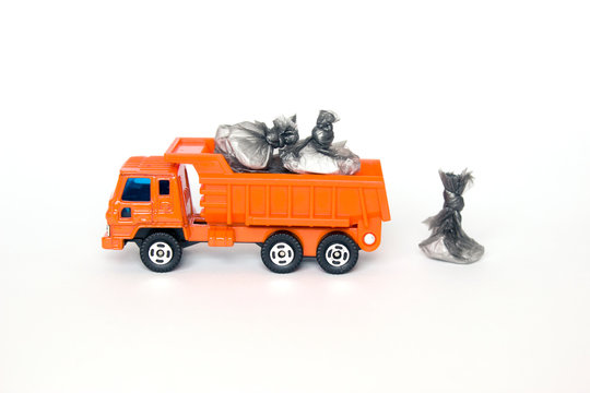 toy garbage truck with garbage bags isolated on white background