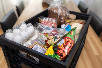 Shopping groceries among which bread, nuts, eggs and waffles in a grocery basket.