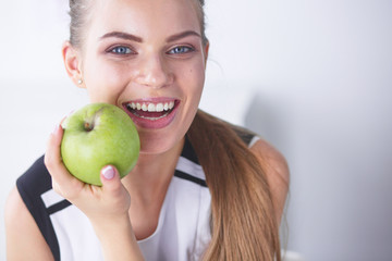 Young beautiful smiling girl with a green apple in hands